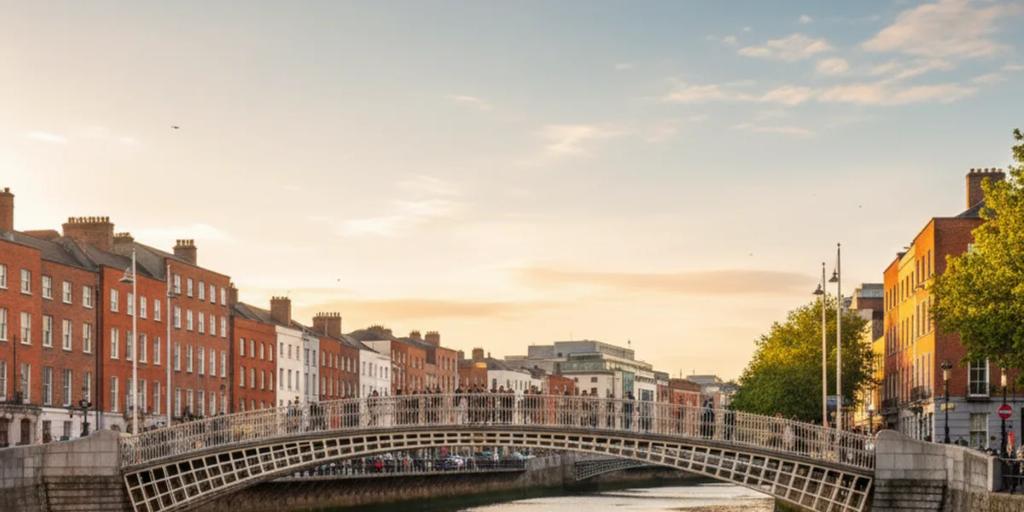 El puente Ha'penny arqueándose sobre el río Liffey en Dublín al anochecer